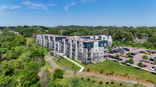 A large apartment complex with a parking lot in front.