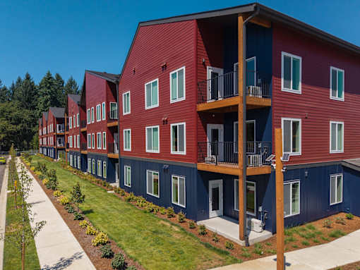 A red and blue building with balconies and windows.