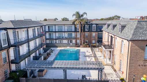 A large apartment complex with a pool in the middle.