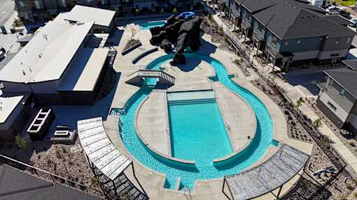 A swimming pool surrounded by a concrete deck and a metal railing.