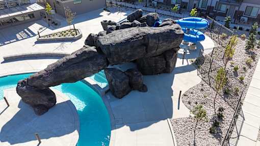 A large rock formation is in the middle of a swimming pool.