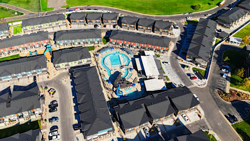 A large swimming pool is surrounded by apartment buildings.
