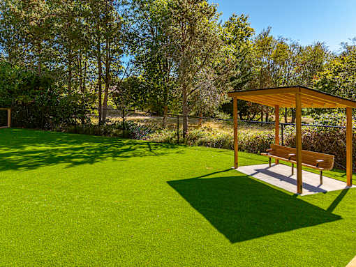 A park with a bench and a pavilion.
