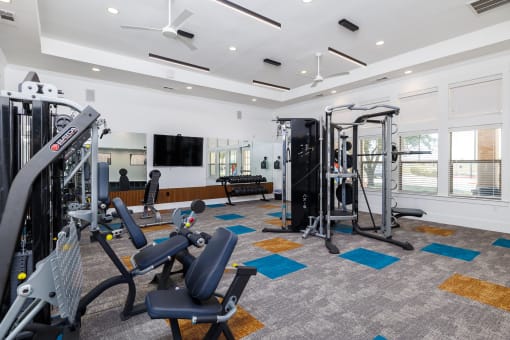 a gym with exercise equipment and a television