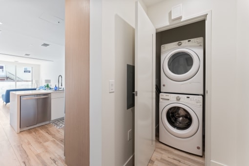 a front loading washer and dryer in a laundry room with a door to