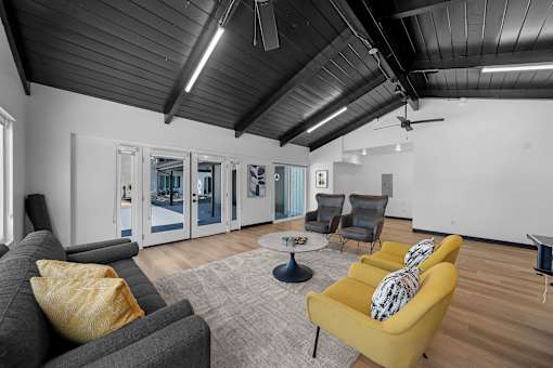 A living room with a grey couch, yellow armchair, and a coffee table.