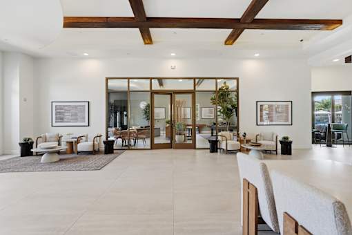 A spacious room with a white floor and a ceiling with wooden beams.