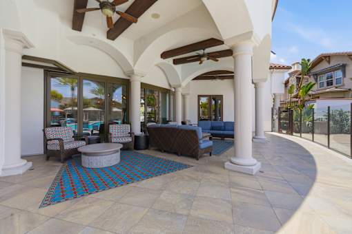 A patio with a table and chairs and a fan.