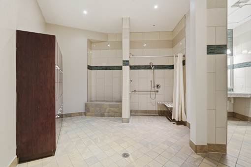 A bathroom with a walk-in shower and a wooden door.