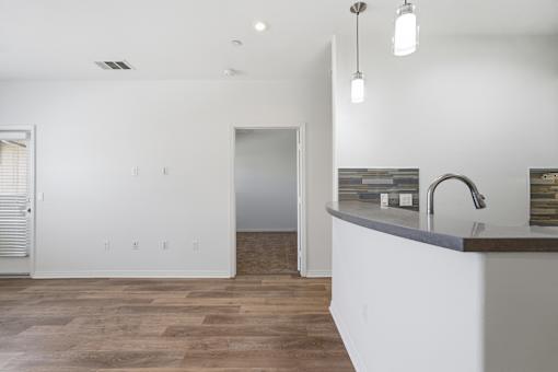 A kitchen with a white island and wooden floors.