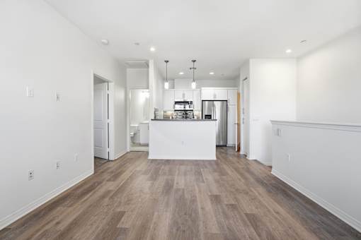 A kitchen with a white island and wooden floors.