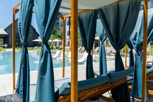A poolside area with sunshades and loungers.
