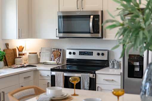 A modern kitchen with a stove, microwave, and oven.