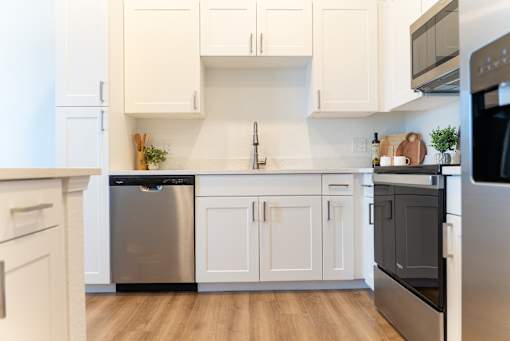 A modern kitchen with white cabinets and stainless steel appliances.