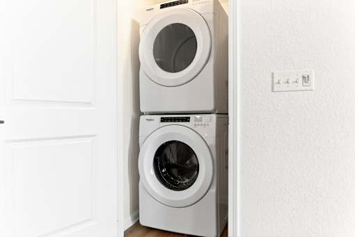A white washing machine is placed in a white door.
