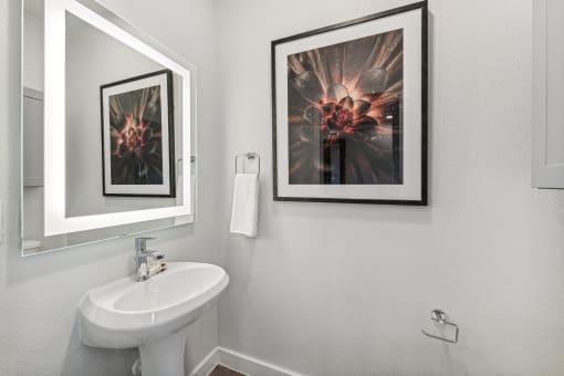 a bathroom with a sink and pictures on the wall