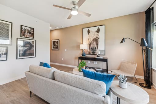 a living room with a couch and a horse on the wall