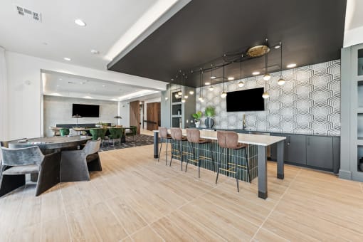 a lobby with tables and chairs and a bar and a television