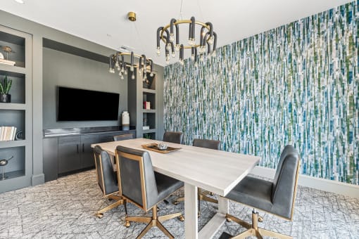a dining room with a wooden table and chairs and a large wall mural of trees
