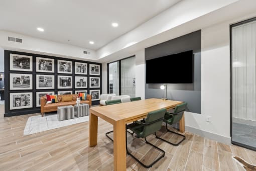 a conference room with a table and chairs and a television