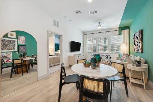 a living room and dining room with a table and chairs