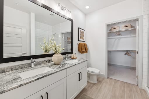 a white bathroom with a large mirror and a toilet