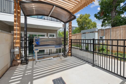 spacious patio with grill and black fence