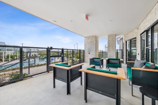 a balcony with tables and chairs and a view of a pool