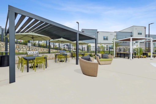 a rendering of a patio with tables and chairs at a building