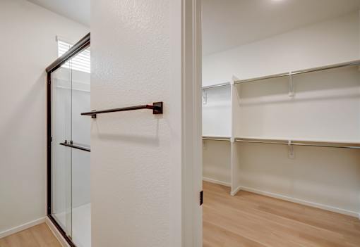 A white closet with a sliding door and shelves.