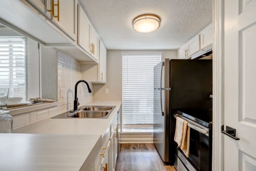 a kitchen with white cabinets and black appliances