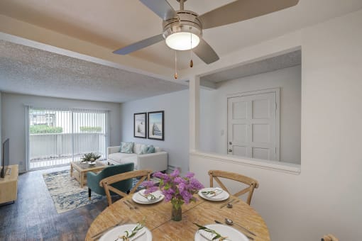 a living room with a ceiling fan and a dining table