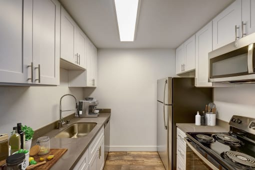 a kitchen with white cabinets and a stainless steel refrigerator