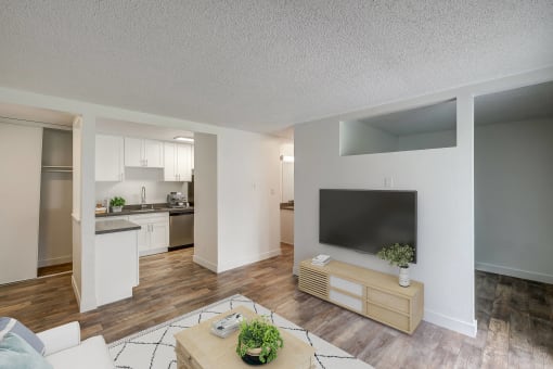 an open living room and kitchen with a large tv