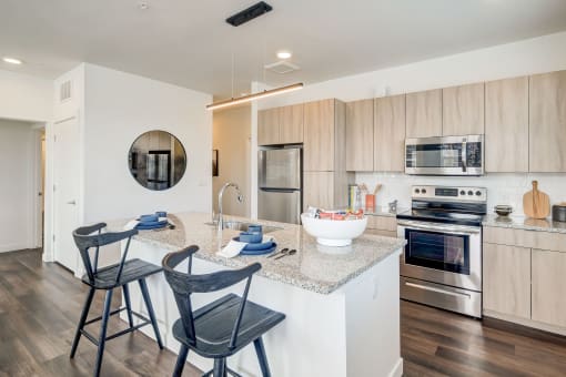 a kitchen with an island and a counter top with two chairs