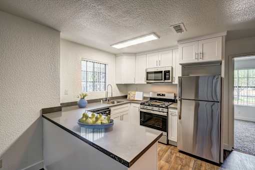 A kitchen with a stove, oven, refrigerator, and microwave.