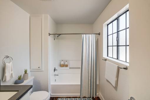 A bathroom with a toilet, sink, and shower.