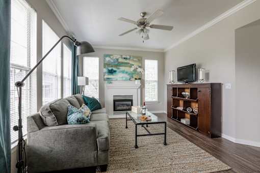 Living room with grey couch at The Retreat at Fox Hollow apartments for rent in Lakewood, CO.