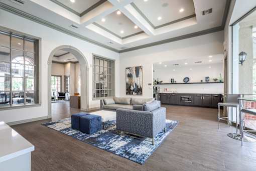 Living room with grey sofa and blue rug at The Retreat at Fox Hollow Lakewood, CO apartments.