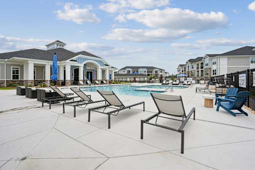 A poolside area with chairs and umbrellas.