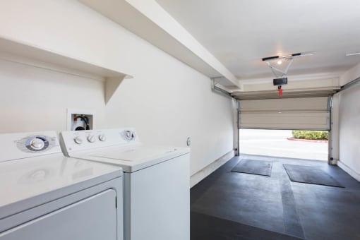 a laundry room with a washer and dryer and a garage door