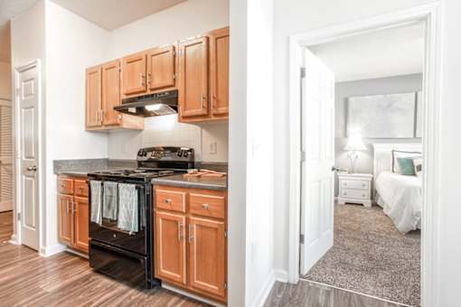A kitchen with wooden cabinets and a black oven.