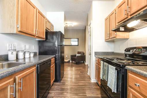 A kitchen with black appliances and wooden cabinets.