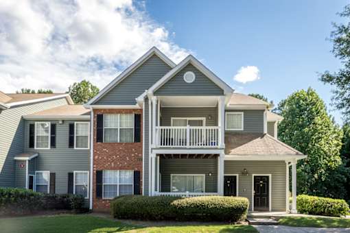 A two-story house with a balcony on the second floor.