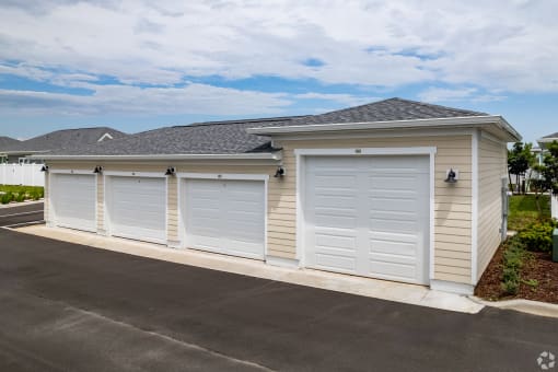 a row of three garage doors on the side of a house