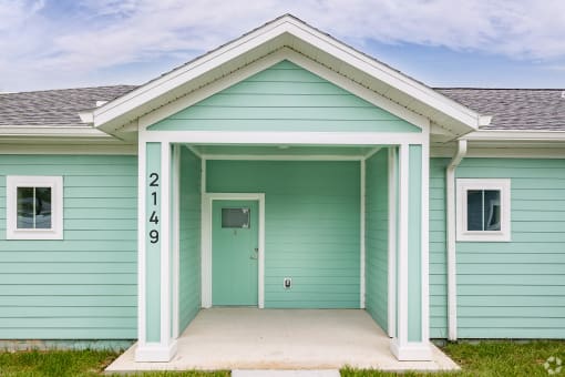 the front of a blue house with a front porch