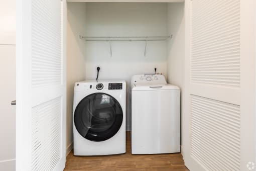 a laundry room with a washing machine and a washer and dryer