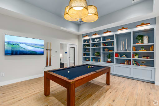 a games room with a pool table and a tv