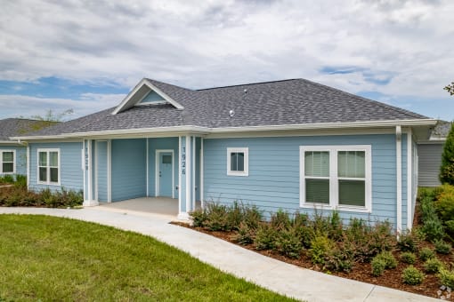 a blue house with a sidewalk in front of it