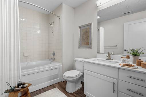 A white bathroom with a tub, toilet, and sink.